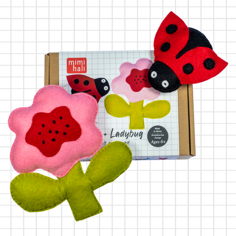 Felt ladybug and flower toys with packaging on a grid background