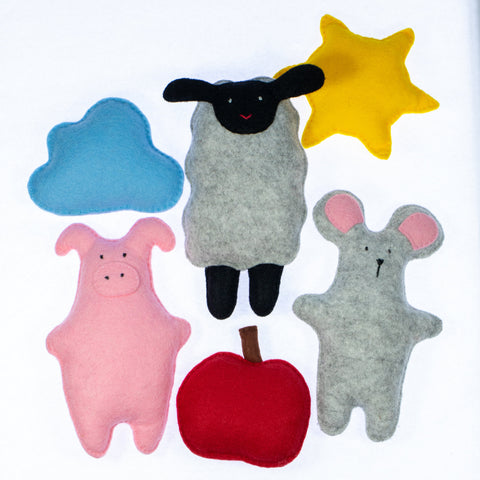 Set of felt animal toys including a sheep, pig, mouse, and apple on a white background