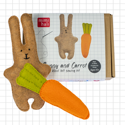 Wool felt sewing kit with bunny and carrot design on a grid background