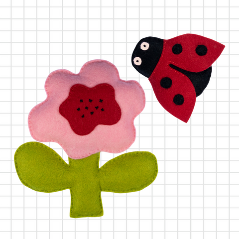Flower and ladybug toy figures on a grid background