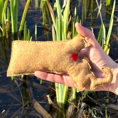 Hand holding felt massachussets with a red heart against a natural background