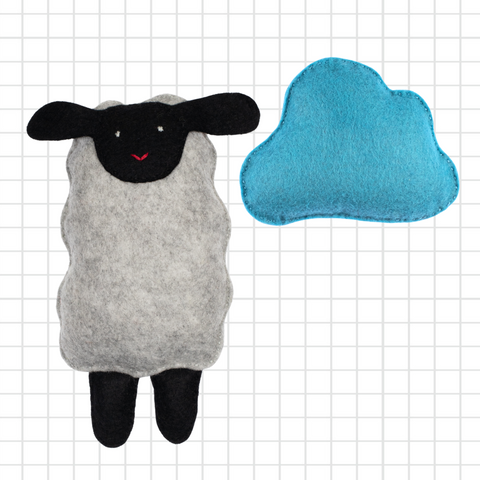 Plush sheep toy with a blue heart on a grid background