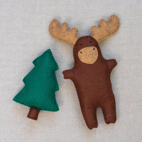 Felt moose and tree felt plush toys on a neutral background
