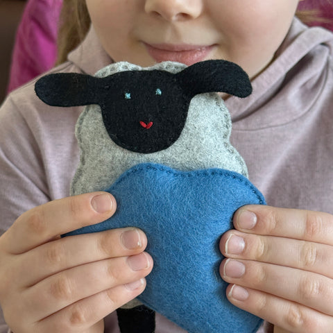 kid holding felt sheep and cloud
