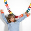 Child with arms outstretched with colorful letters against a white background