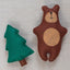 Felt bear and tree toy on a linen fabric background