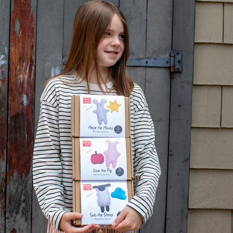 girl holding 3 farm kits
