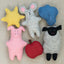 Set of colorful felt animal toys including a sun, mouse, pig, and sheep, cloud, and apple on a beige background.