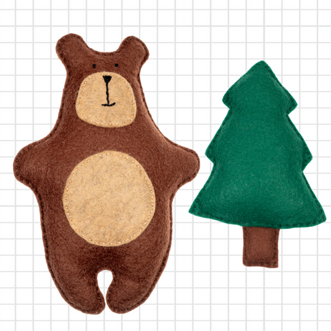 Brown bear-shaped toy and green tree-shaped toy on a grid background