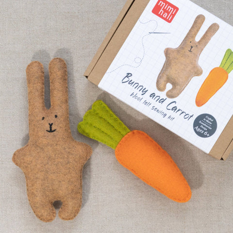 Felt bunny and carrot toys with packaging on a neutral background