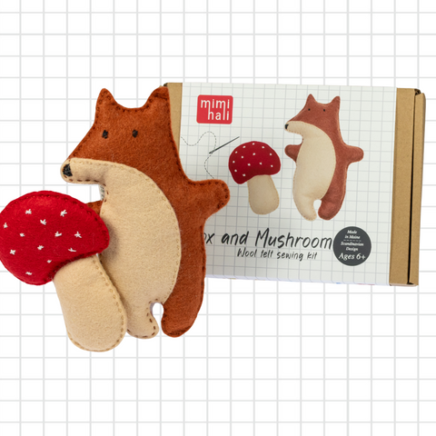 Felt fox and mushroom sewing kit with packaging on a grid background