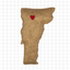 Felted animal-shaped object with a red heart on a grid background