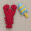 Red lobster plush toy and blue and yellow striped buoy on a neutral background