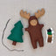 Felt moose and tree toy with threads on a neutral background